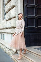 a lady wears a beige sweater with light pink tulle skirt